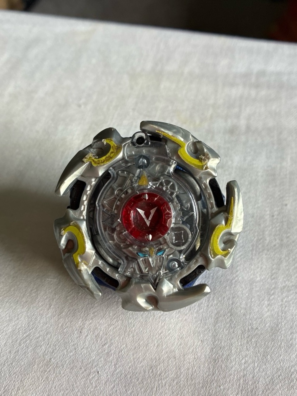 Beyblade Silver Metal Spinning Top with Red Center Gem and Yellow Accents